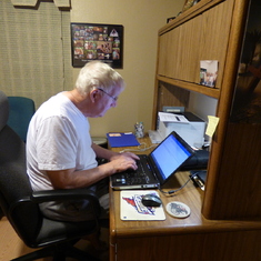 At his computer