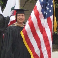 Holding the US Flag as part of the ceremony for my MBA graduation.