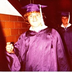 The first person is Kevin Smith, behind him is Rolland Slagle in their graduation garb. 1977