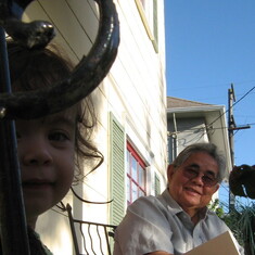 Sofia and Lolo Romy reading on the front porch 