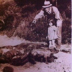 Rosa Raye and Crit Cox (grandfather) looking at the newborn piglets.