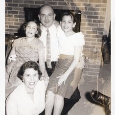 Rosann sitting on her dad's lap on the right, wearing that same smile she had all her life