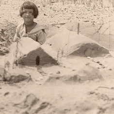 1925 circa.  Rosemary building sand castles.  Location unknown.