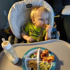 Levi enjoying his dinner, watching Blues Clues.