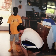 Big Brother helping him get ready for his first baseball game 8 years old