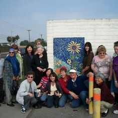 Group shot of decorative arts classmates who each created ceramic pieces to make this mosaic in Susan's honor.