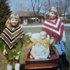 The three sisters in their ponchos made by grandma.