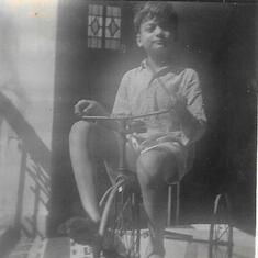 The 5 year old riding his green tricycle, again the family heirloom that I too rode as a child.