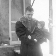 Tom and Peggy in front of basement home, December 1952
