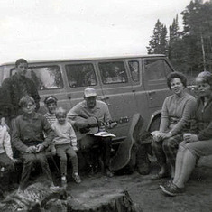August 1967, Tom playing guitar at campfire at Grand Marais (seated: Kevin, Mark, Patty, Tom, Bev, Donna Johnson; standing: Jerry Evans, Jr., Steve Johnson))