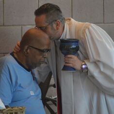 Tyrone  taking communion from Senior Pastor Rev. J. Dwayne Johnson