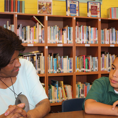 Verne Oliver talks with a student at St. Brigid's school in the new library. Rachel Ohm/ The Local.