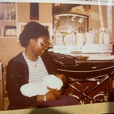1981...@Kilburn, London- Vickie carrying baby Evelyn 