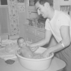Dad bathing one of the twins. C. 1958