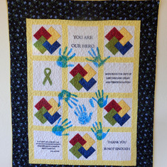 The quilt provided by LifeCenter NW. The hand prints left to right and then top to bottom are Bill Berger, Meg Berger, Seth Robertson, baby Bennett foot print, Sarah Robertson, big Will Berger center, Dave Berger and Amber Berger.