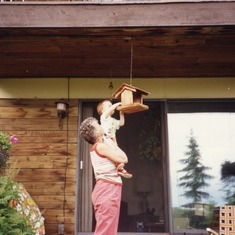 A boy needs to learn how to load the bird feeder with peanuts for the Blue Jays.